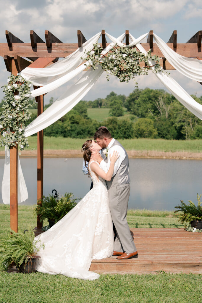 summer wedding bride and groom first kiss