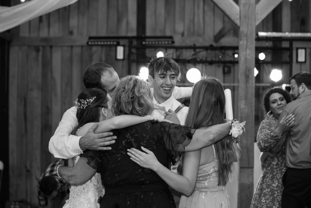 family hug on dance floor at wedding