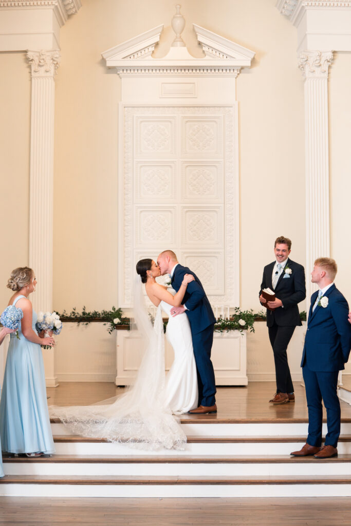 bride and groom first kiss spring wedding ceremony